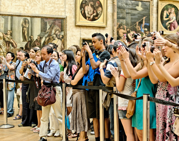 Turistas tiram foto do quadro Mona Lisa, no Louvre. 
