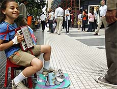 Laura, 5, toca sanfona na Calle Florida, calado no centro, em troca de alguns pesos