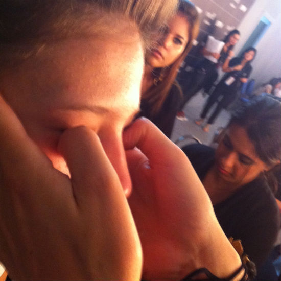 Fabiana Gomes, da MAC, faz massagem ao redor dos olhos da modelo no backstage do desfile da Idice