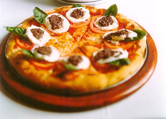 Na Bráz, a pizza caprese (foto) tem mozarela de búfala, tomate caqui, manjericão e pesto de azeitonas pretas