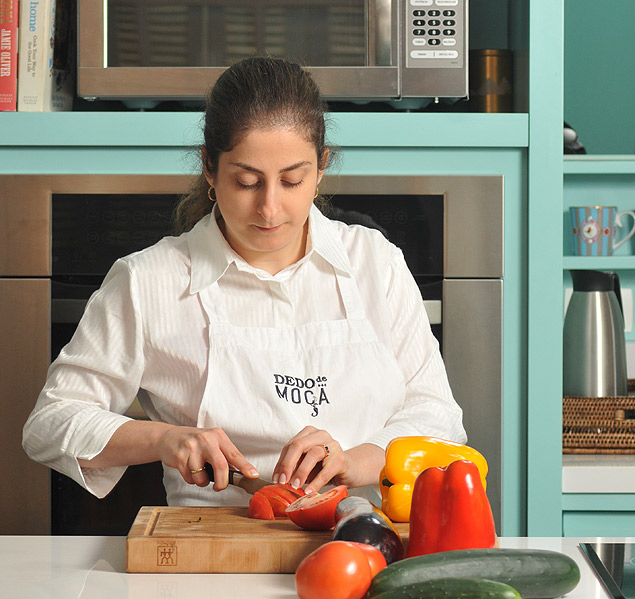 A musicoterapeuta Helena D'Angelo manipula alimentos na cozinha Dedo de Moa, em So Paulo