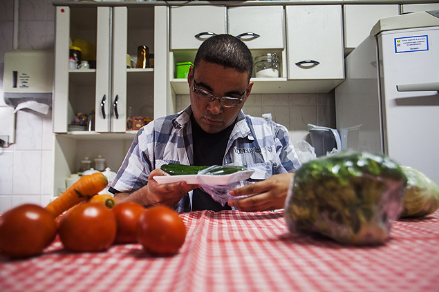 O fotógrafo Marcos Reis, que tem baixa visão, manipula vegetais na cozinha da Fundação Dorina Nowill para Cegos