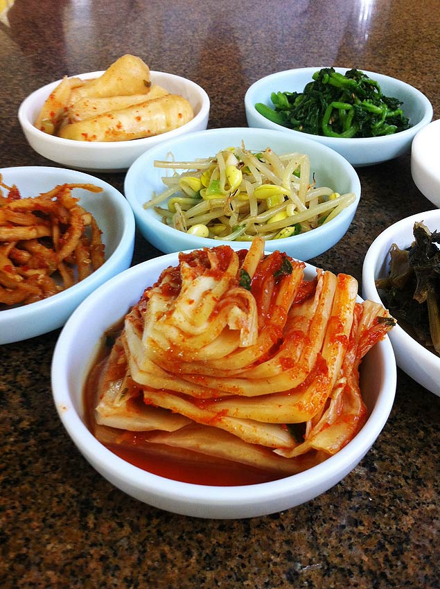 Pores de aperitivos orientais, como kimchi ( frente), do restaurante Aldeia da Pedra