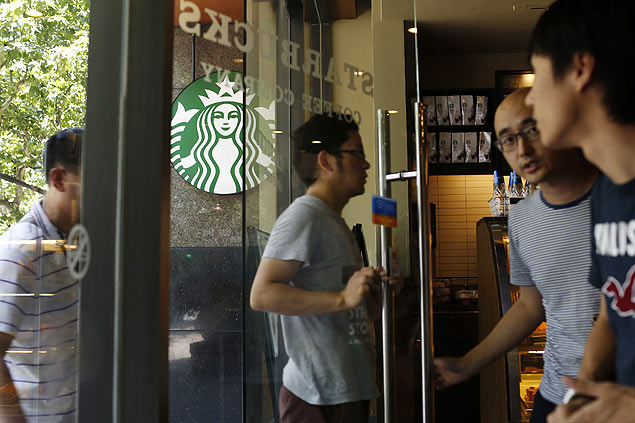 Consumidores entram em unidade da Starbucks em Xangai nesta tera-feira (22)