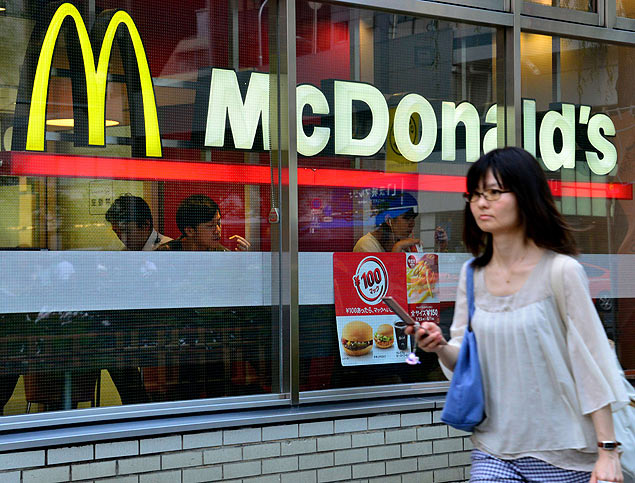 A pedestrian passes before a McDonald's restaurant in Tokyo on July 23, 2014. A scandal involving expired meat sold by a China unit of US food supplier OSI Group spread to Japan on July 22, as McDonald's confirmed that the now shut factory provided Chicken McNuggets to its restaurants. AFP PHOTO / Yoshikazu TSUNO ORG XMIT: TOK5782