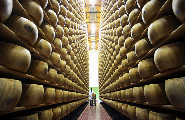 ORG XMIT: 150401_1.tif Parmigiano-Reggiano consortium quality control chief Igino Morini, background center, checks a wheel of Reggiano cheese, at the Parmigiano-Reggiano storehouse, in Bibbiano, Italy,Tuesday, April 1, 2008. (AP Photo/Marco Vasini) 