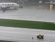 Tcnico da Infraero faz a medio de gua na pista principal do aeroporto de Congonhas