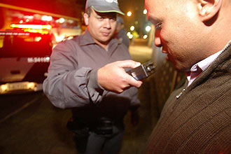 Policial militar aplica teste do bafmetro em motorista em blitz na zona leste de SP