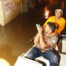 Moradores usam barco e lanterna para vigiar suas casas e evitar que elas sejam saqueadas