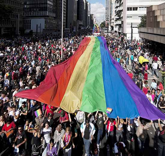 Participantes da Parada Gay de São Paulo carregam bandeira arco-íris