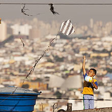 Menino solta pipa em laje de casa na cidade de So Paulo; Indaiatuba probe brincadeira