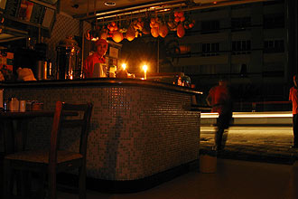 Sem poder voltar para casa, funcionários de padaria na avenida Angélica, na região central, usam velas para iluminar o ambiente