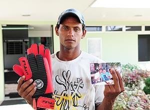 Rodrigo de Souza, irmão do goleiro Bruno do Flamengo, mostra um par de luvas que ganhou do jogador