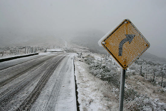 Flocos de neve cobrem estrada que leva ao Morro da Igreja, em Urubici (SC). Neve deve continuar na região.