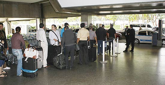 Passageiros fazem fila para pegar táxi no aeroporto de Cumbica, em Guarulhos (SP); espera chega a durar até uma hora