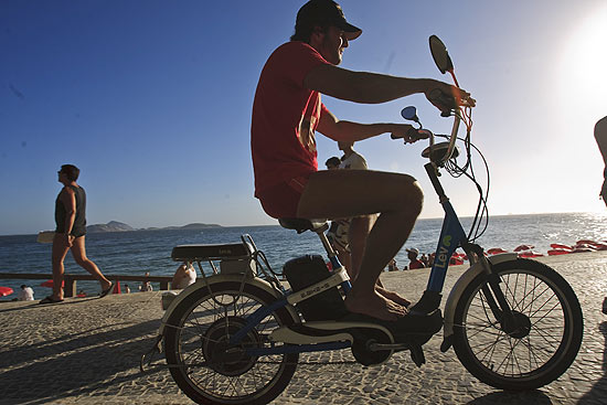 Advogado Jonas Ferreira, 38, posa para fotos com sua bicicleta elétrica na praia do Arpoador, zona sul do Rio
