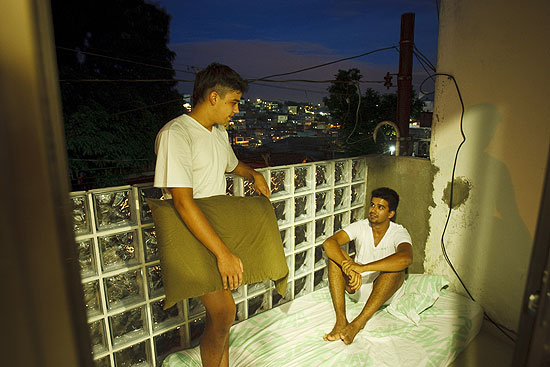 Irmãos Matheus e André conversam na sacada da casa onde moram em Pirituba, zona oeste de São Paulo