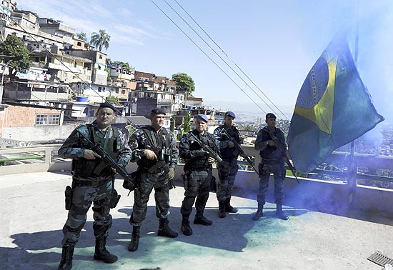 Polcia celebra tomada de morro no Rio com hasteamento de bandeira do Brasil e sinalizadores de fumaa azul