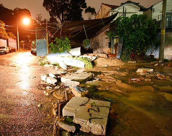 Muro de garagem foi destrudo pelas guas do lago da Aclimao que rompeu, em So Paulo, aps chuva