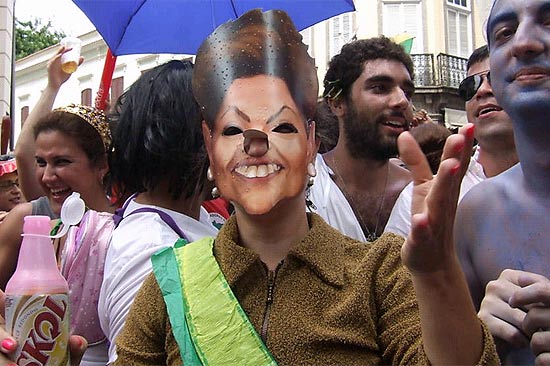 Uma foli distribua acenos e sorrisos com a mscara da presidente Dilma Rousseff