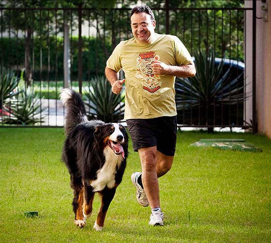 Rogério Bonfim brinca com Bono na creche para cães construída no prédio onde mora, no Real Parque (zona oeste de SP)
