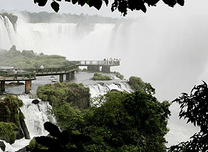 Turistas caminham por passarelas sobre as cataratas no Parque Nacional do Iguaçu, em Foz do Iguaçu, no Paraná