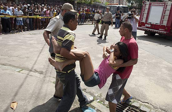 Pessoas carregam mulher após ataque a escola no Rio de Janeiro