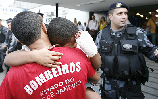 Sargento do Corpo de Bombeiros Adriano carrega seu que ficou ferido no ataque a escola do Rio; veja mais imagens