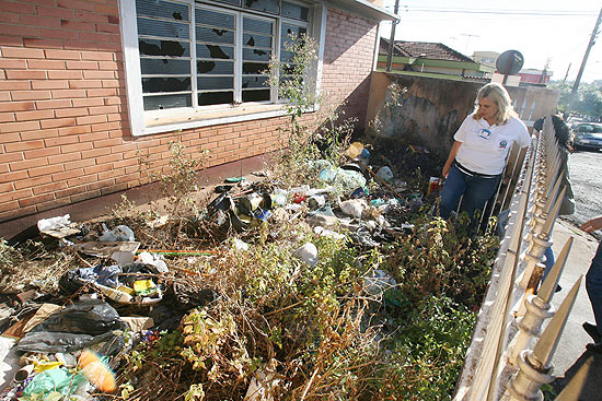 Agentes da prefeitura retiram entulho de casa no bairro Campos Elseos, em Ribeiro Preto (SP)