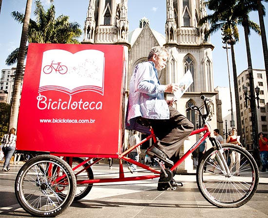 Robson Mendonça e sua bicicloteca na praça da Sé; acervo de sua biblioteca sobre rodas inclui Truman Capote e Lima Barreto