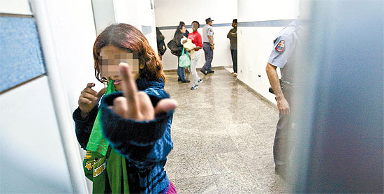 Menina recolhida pela Polcia Militar na Vila Mariana faz gesto obsceno para fotgrafo em delegacia da zona sul de SP