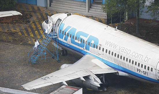 Homem caminha ao lado das aeronaves sucateadas da Vasp em Congonhas