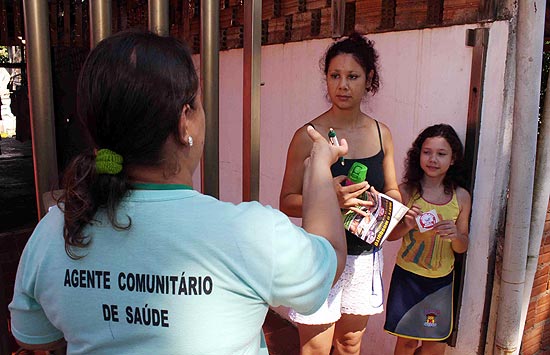 Agente de sade conversa com moradores sobre campanha contra a dengue 