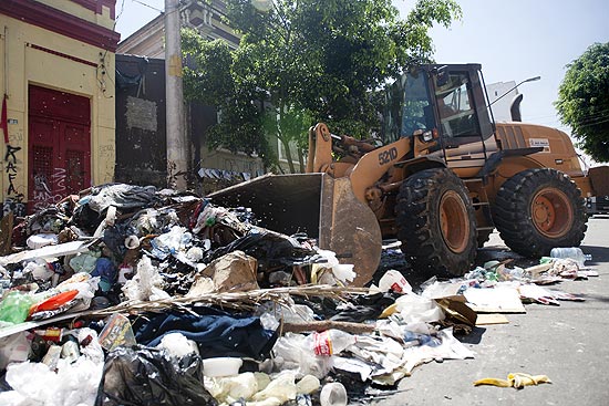 Prefeitura utiliza retroescavadeira para retirar lixo e entulho deixado após saída de dependentes da região