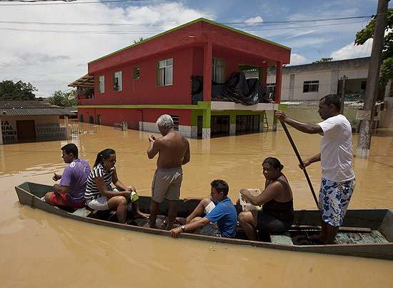 Moradores em rua alagada no bairro de Trs Vendas, onde rio Muria invadiu cidade aps o rompimento de dique