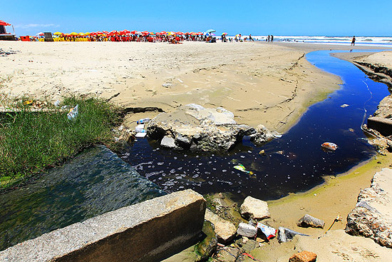 Esgoto é despejado na praia da Vila Caiçara, em Santos. A cada 100m a praia é cortada por despejo de água poluída