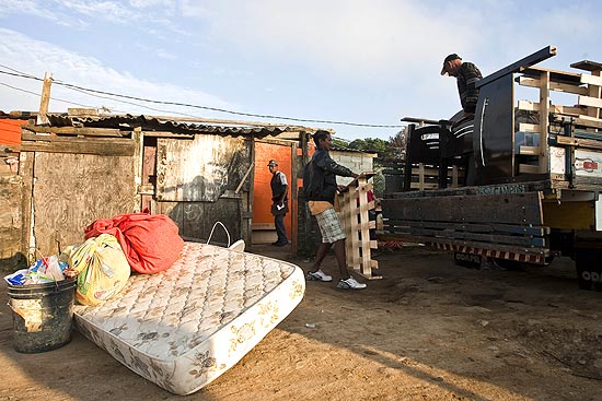 Moradores retiram móveis dos barrados no Pinheirinho após reintegração; casas já estão sendo demolidas