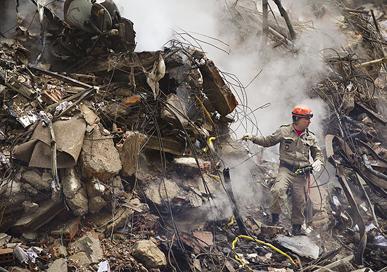 Bombeiro busca vítimas nos escombros dos prédios que caíram no centro do Rio; veja galeria de fotos