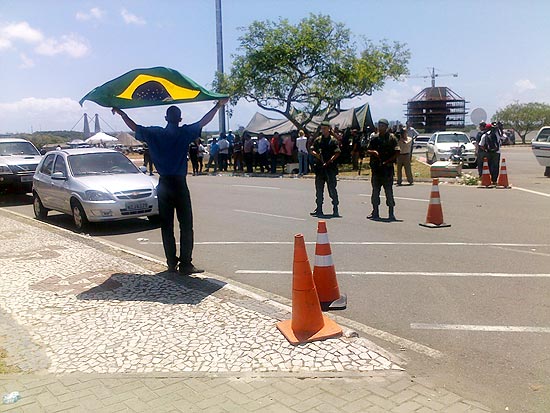 Manifestante exibe bandeira do Brasil em frente à Assembleia Legislativa, ocupada por <span class=