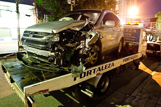 Carro da empresária fica destruído após bandidos baterem; vítima fugiu após pular do veículo em movimento