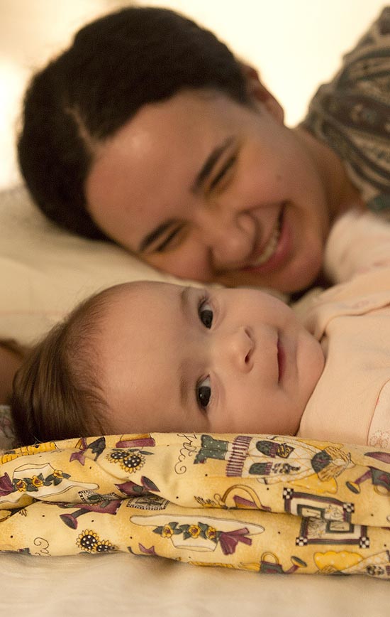 Simone Tafinel, 27 e sua filha Mariana de cinco meses na cama do casal