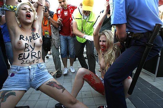A brasileira Sara Winter, 19, (à esq.) é presa em Kiev, na Ucrânia, durante as quartas-de-final da Eurocopa