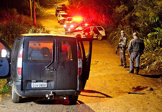 Policiais perto do carro usado por bandidos que atiraram contra a base da PM na região de Parelheiros, zona sul de São Paulo