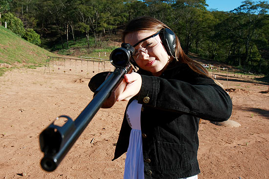 Fernanda Bortolotti, 21, usando rifle de calibre 22 no Clube de Tiro de Monte Alto (SP)