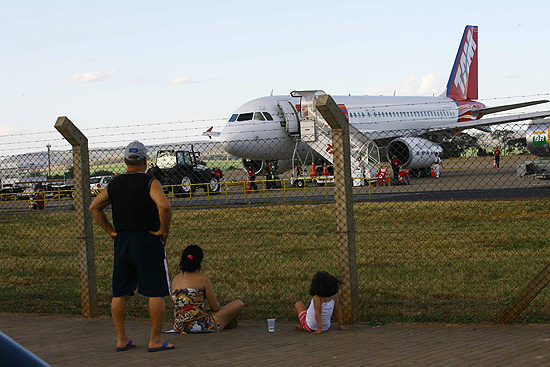 Pessoas observam avio parado na rea de embarque do aeroporto Leite Lopes, em Ribeiro Preto
