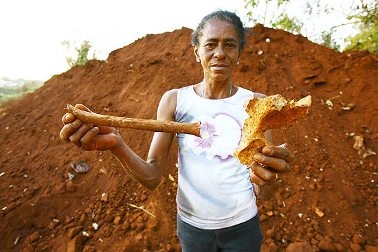 Marlene Ferreira de Souza mostra ossos que ela encontrou em monte de terra retirado do cemitrio de Bonfim