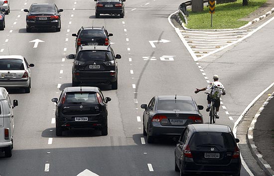 Ciclista anda pela movimentada avenida 23 de maio em maio, próximo ao Parque do Ibirapuera, em Sao Paulo
