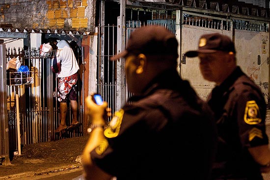 Guardas civis observam corpo de Fernando Pereira de Melo, 23, morto em Taboo da Serra