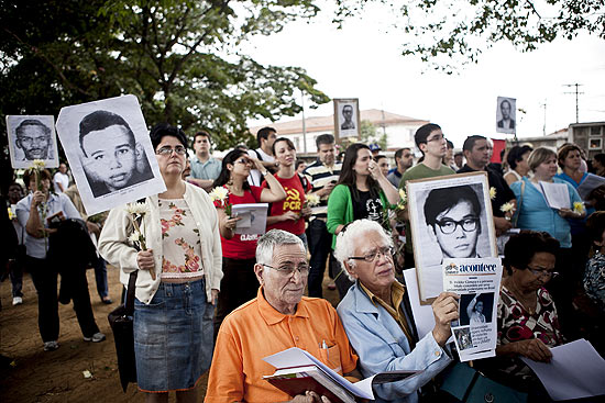 Militantes carregam cartazes em ato em homenagem a vítimas da ditadura em São Paulo