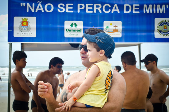 Lucas Zani Galhardo, 1 ano e 7 meses e seu pai Daniel Gualhardo, 33, com a tradicional pulseirinha de identificação do Projeto "Não se perca de mim" na praia Pitangueiras, no Guarujá, litoral de SP